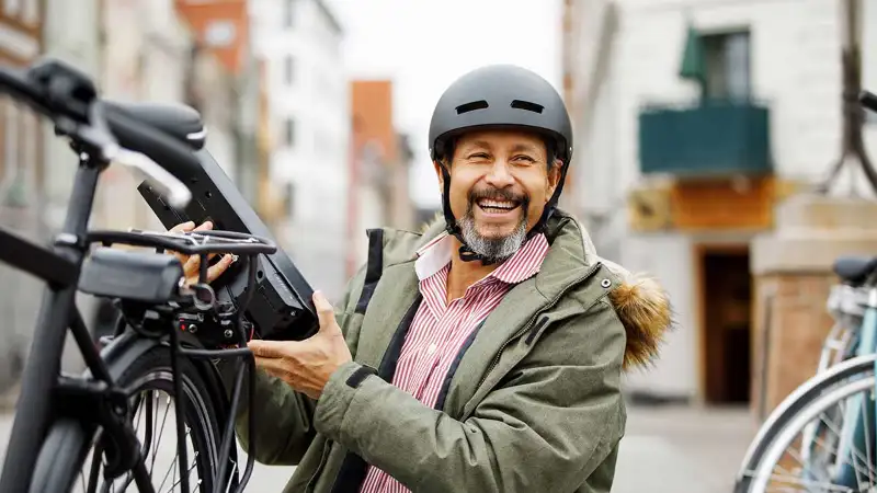 Ein lachender Mann neben seinem S-Pedelec Ein lachender Mann neben seinem S-Pedelec